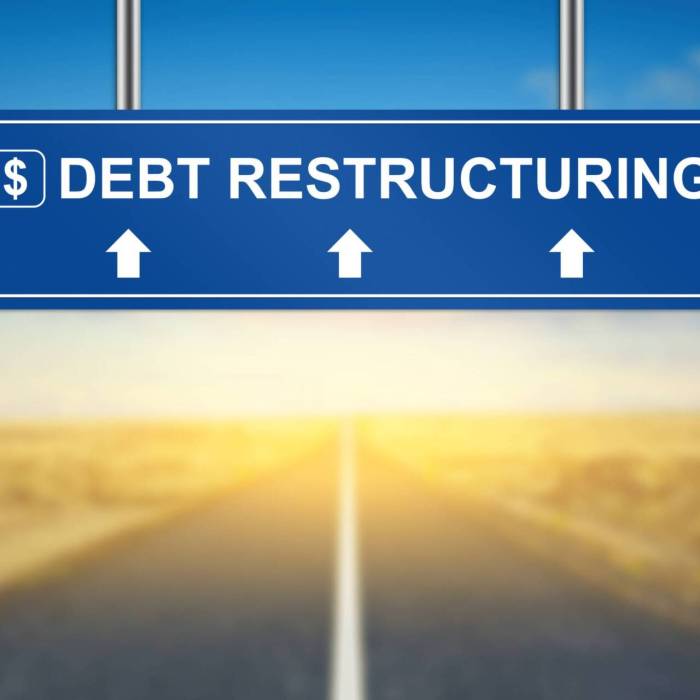 debt restructuring words on blue road sign with blurred background